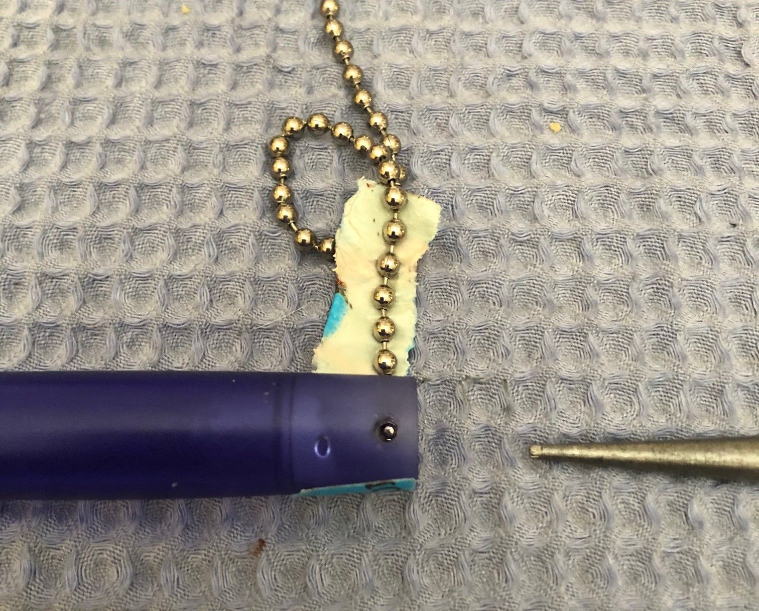 The pen with the end cap removed and the pull chain ball seen through the retention holes.