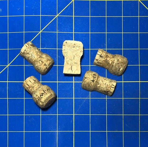 Picture of champagne corks cut lenthwise on cutting mat to make knife rests.