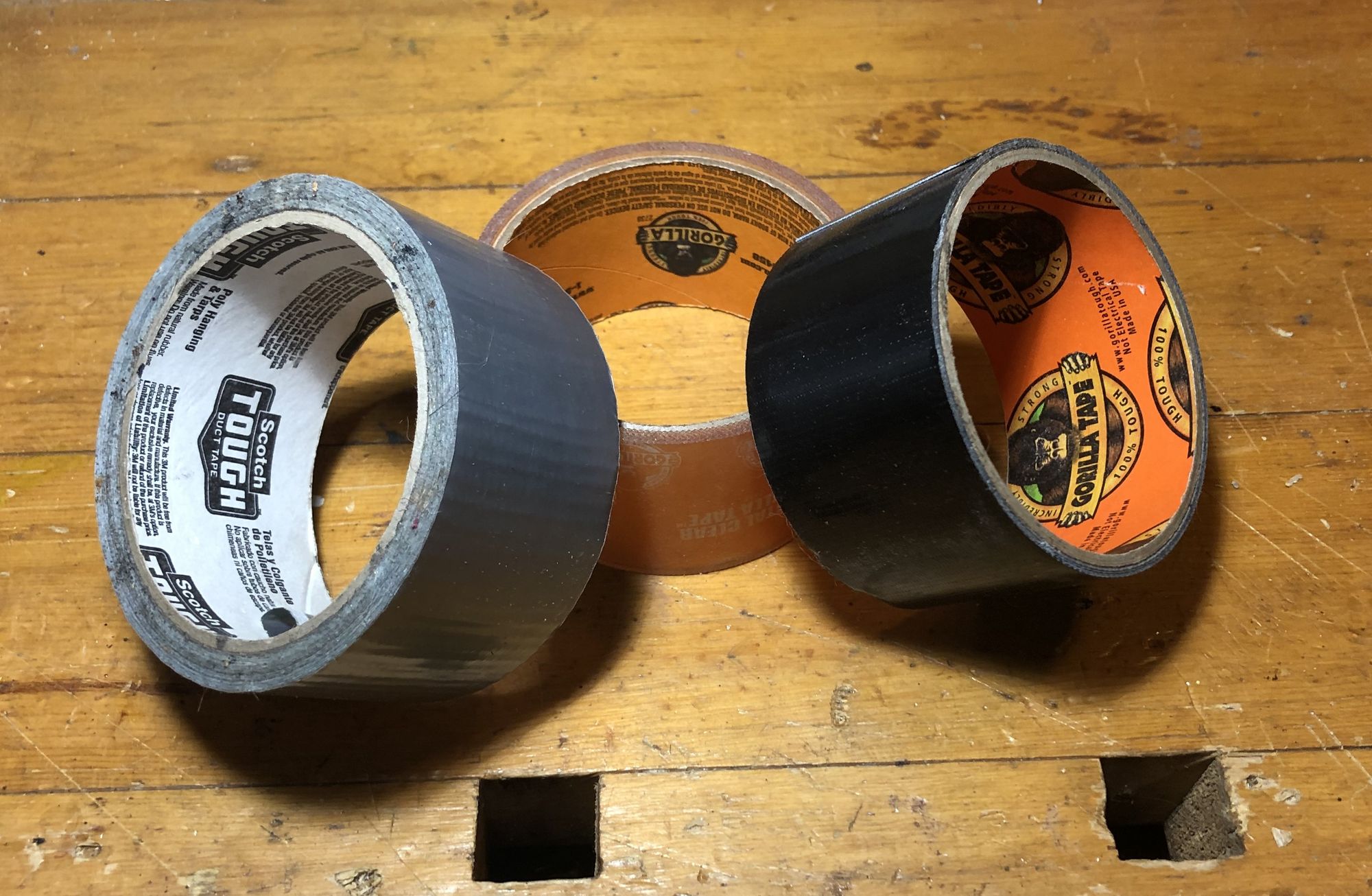 Three rolls of duct tape, silver, black and clear.
