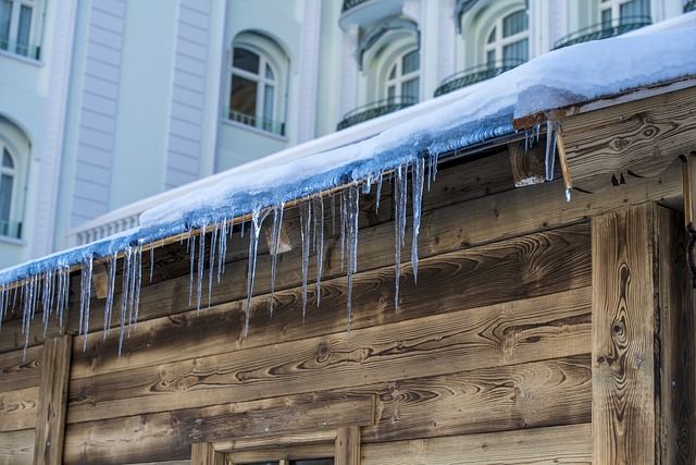 A picture showing an ice dam and icicles on an older wooden building.